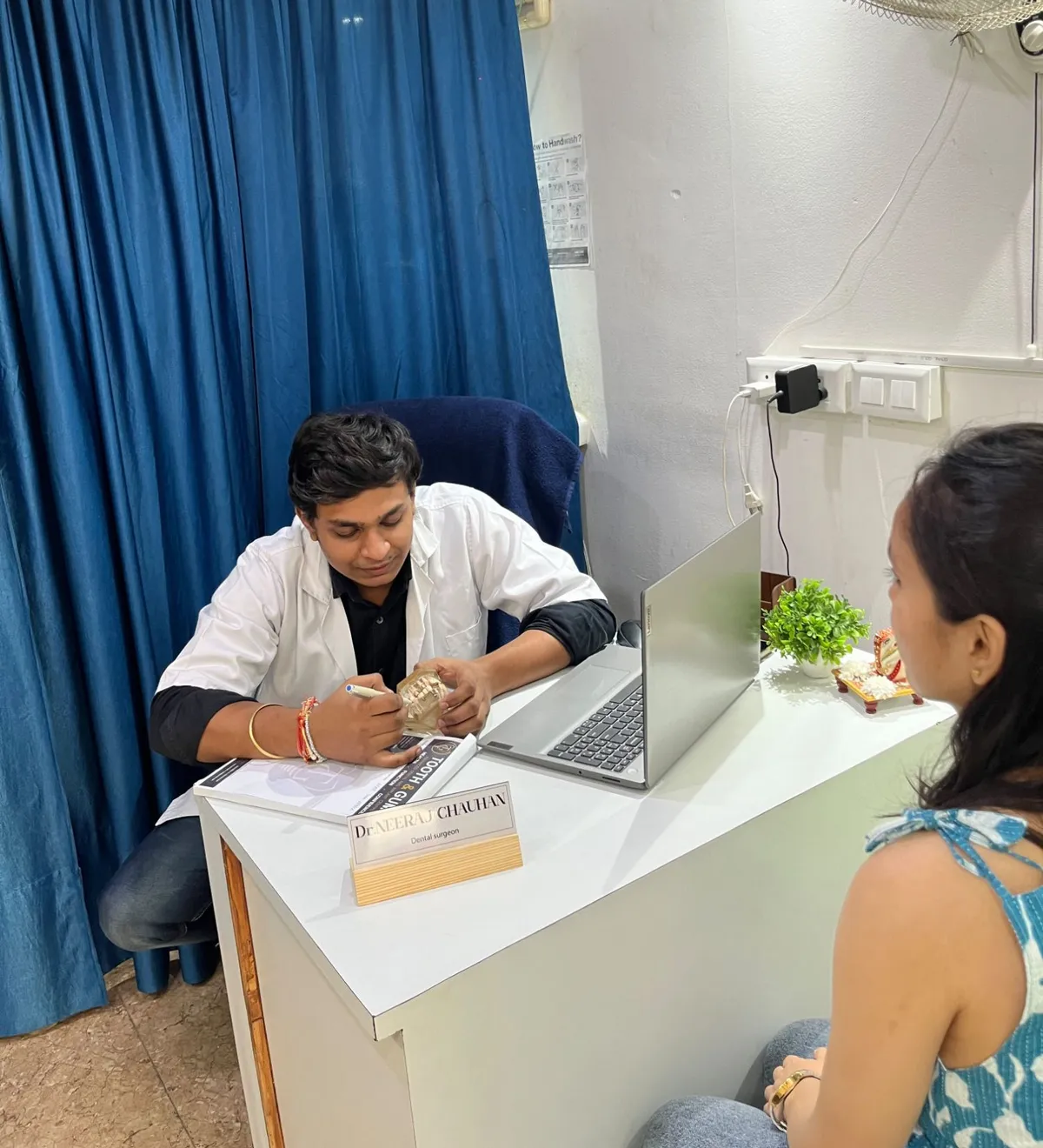 Dr. Neeraj Chauhan explaining treatment to a patient using a dental model at Tooth and Gums, Greater Noida